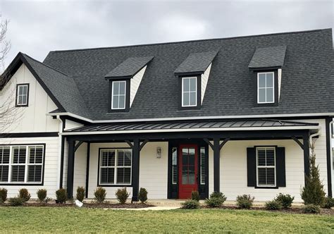 metal roof on white brick house|brick house with black shingles.